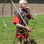 Replica cornu. Reconstructed by the Ermine Street Guard. Image: MCB Musician blowing a copper-alloy cornu, held over his right shoulder.