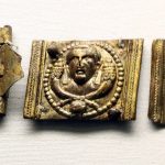 Copper-alloy embossed belt plates and buckle from Chassenard (FRA). Image: Cangadoba (CC BY-SA 4.0) A buckle (left) and two belt plates (centre and right) with an embossed portrait over crossed cornucopiae.