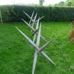 Double-ended wooden stakes lashed together in threes as obstacles to form large caltrops. Reconstructed by the Ermine Street Guard. Image: MCB Four sets of three stakes with points at either end lashed together.