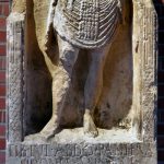 Tombstone of Pantera, auxiliary archer of cohors I Sagittariorum. He holds a bow in his left hand and (originally) a scroll in his right and wears two belts, one each for sword and dagger, and has a six-strapped apron. Image: Marcin Szala Infantryman stands within a niche, with the remains of a scroll in his right hand and a composite bow in his left. The tombstone is missing from the shoulders upwards.