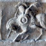 Relief (possibly depicting a Republican cavalryman) from the Lacus Curtius in the Forum Romanum that marked the traditional location where Curtius supposedly leaped into a chasm (other myths are available!). This is a later copy of a 2nd century BC relief. Image: MCB A horseman with a spear in his right hand and a small round shield (parma) in his left. He wears a helmet with a crest.