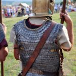 Rear view of a Roman re-enactor wearing a scale body defence, often colloquially called lorica squamata (although never actually named that in any source). Note the leather edging around the neck and buckles at the side to fasten it (plausible speculation). Image: Saturnian (PD) Rear view of a re-enactor wearing ferrous (or tinned) scale armour.