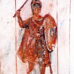 Depiction of a Late Roman soldier from a fresco in the Via Latina catacomb in Rome. Image: JCNC A soldier wearing a Kammhelm and clad mostly in red stands with his sword raised and oval/round shield by his side.