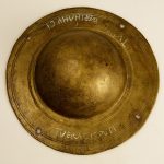 Circular copper-alloy shield boss from Zwammerdam with a hemispherical dome. There are punctim ownership inscriptions, including T(urma) VERACIS PUPI, indicating it belonged to a cavalryman. Image: National Museum of Antiquities, Leiden Shield boss with a brassy patina, with four peripheral holes for shield nails (missing), concentric inscribed decorative circles on the flange, and punctim inscriptions.