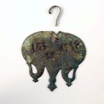 Copper-alloy pendant from Nijmegen (NLD) inscribed punctim with the lettering LEG IX HISP. Image: Museum het Valkhof (Public Domain Mark 1.0 Rear face of a cavalry harness pendant with a pitted, dark green patina with lettering formed from punched dots.
