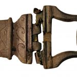 Belt buckle and belt plate from near the Trajanic fortlet at Nether Denton, near Hadrian's Wall. Image: © The Trustees of the British Museum (CC BY-NC- SA 4.0) Broken hinge plate to left, with punctim decoration, and a sub-rectangular buckle hinged to it on the right. Both have a dull, dark green/brown patina.