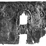 Copper-alloy catapult shield found near Cremona with an embossed inscription, recoding the fact that it belonged to legio IIII Mecedonica and the consular date of its manufacture (AD 45). Image: Notizie degli scavi di antichità 1887 (PD) A monochrome image of a rectangular plate, damaged on the right-hand side, and with an aperture in the centre and embossed text around it.