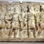 Relief from Cumae (ITA) depicting armed soldiers. Image: Gary Todd (CC0 1.0) Relief showing ten infantrymen with oval shields and sheathed swords on their right hips, plumed helmets, and tunics.