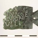 Copper-alloy ownership tag in the form of an ansate panel with punctim inscription LXG / (...) CINNAE/ AMONI/IVLLI identifying it as belonging to Amonius Iullus, in the century of ?Cinna, of the legio X Gemina. Possibly originally attached to a shield. Image: Museum het Valkhof (Public Domain Mark 1.0) Damaged rectangular plate with a surviving ansa on the right-hand side (the left is damaged) punched lettering highlighted in white.